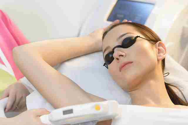 Beautiful woman getting laser hair removal at beauty salon